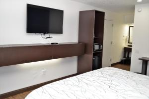 a bedroom with a bed and a flat screen tv at Athena Inn Chattanooga in Tyner