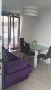 a living room with a purple couch and a table at Apartments Villa Nona II in Umag