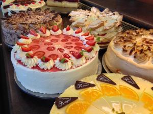 uma mesa com muitos tipos diferentes de bolos e laranjas em Hotel Café Konditorei Köppel em Bingen am Rhein