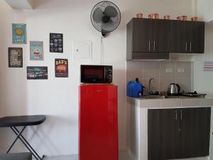 a kitchen with a red refrigerator with a microwave on top at Tagaytay Modern Minimalistic Condo in Tagaytay