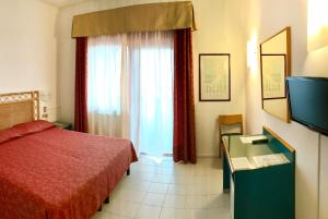 una camera d'albergo con letto rosso e finestra di Hotel Palme a Monterosso al Mare