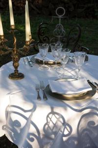 une table avec un tissu de table blanc, des verres et de l'argenterie dans l'établissement Chateau de Canac, à Rodez