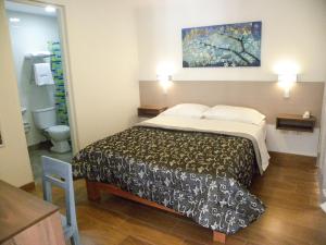 una habitación de hotel con una cama y un baño en Nice Inn Tacna, en Tacna