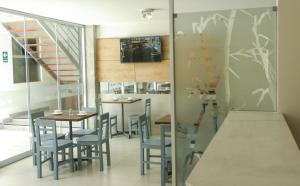una sala da pranzo con tavoli, sedie e una scala di Nice Inn Tacna a Tacna