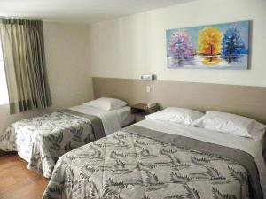 una habitación de hotel con 2 camas y un cuadro en la pared en Nice Inn Tacna, en Tacna