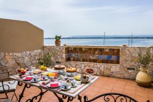 stół z jedzeniem na patio w obiekcie Palazzo Giunta - Porta Marina Ortigia w Syrakuzach