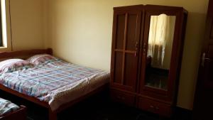 a bedroom with a bed and a wooden cabinet at Amir's Apartment in Nieuw Nickerie