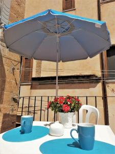 シャッカにあるLa Biforaの傘とカップ2杯付きテーブル