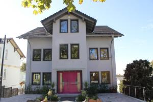 a white house with a red door at Haus Feriendomizil in Ahlbeck