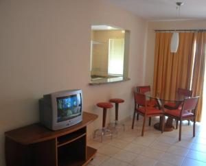 a living room with a tv and a table and chairs at Royal Park - Achei Férias in Caldas Novas