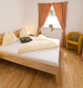 a bed in a bedroom with a window and a chair at Appartement Rofan in Pertisau