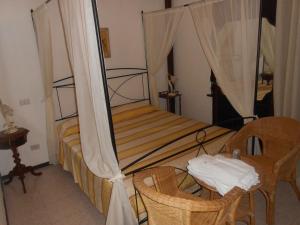 ein Schlafzimmer mit einem Himmelbett mit einem Tisch und Stühlen in der Unterkunft Garden Villa Sea View in Riomaggiore