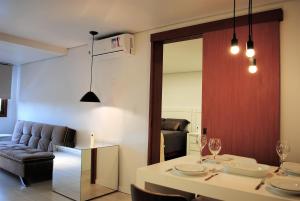 ein Wohnzimmer mit einem Tisch und einem Sofa in der Unterkunft Apartamento Moderno Centro Gramado in Gramado
