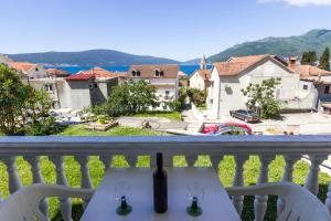 a table on a balcony with a view of a city at St. Roko Guest House in Tivat