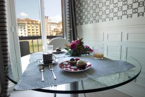 a glass table with a plate of food and a drink at Specchi Su Pontevecchio in Florence