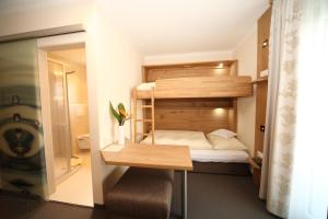 シュラートミンクにあるEdelweiss Apartmentsの二段ベッド1組、デスクが備わる小さな客室です。