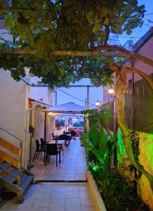 d'une terrasse avec des tables, des chaises et un arbre. dans l'établissement Rosana guest house, à Nazareth