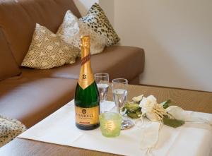 a bottle of champagne sitting on a table with glasses at Appartement Rofan in Pertisau