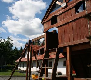 a set of wooden play structures in front of a house at Chalupa na dobrém místě in Prostřední Bečva