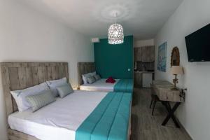 a bedroom with two beds and a green wall at Blue Bay Hotel in Skala Potamias