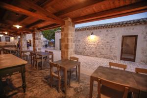 een restaurant met tafels en stoelen en een bakstenen muur bij Agriturismo Le Chiuse di Guadagna in Scicli