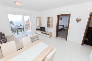 a white living room with a view of the ocean at Apartments Matanovi Dvori in Makarska