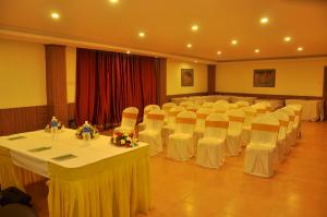 a banquet hall with tables and chairs in a room at Vinayaga Inn by Poppys, Ooty in Ooty