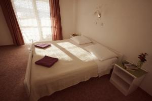 a bedroom with a white bed with two towels on it at Villa Marijana-Direktno na moru in Seline