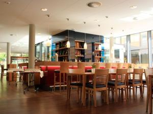 a restaurant with wooden tables and chairs and windows at Hotel Franz in Essen