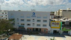 un gran edificio blanco con un cartel. en Hotel Antillano, en Cancún