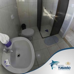 a bathroom with a toilet and a shower at Hotel Tubarao in Tubarão