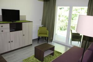 a living room with a couch and a tv at Hotel Stanger in Lovran