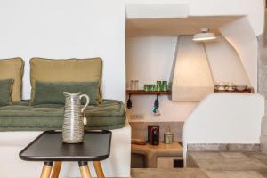 a room with a bed and a table with a vase on it at Vathisthea in Kithnos