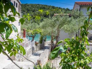 a path leading down to the ocean with houses and trees at Apartments Antea & Magdalena in Pirovac