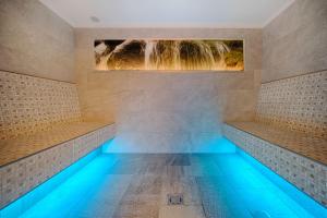 een zwembad met een watervalschilderij aan de muur bij Hotel Mair in Campo Tures