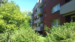 budynek z czerwonej cegły z drzewami przed nim w obiekcie Apartment Bexor D19 w Hanowerze
