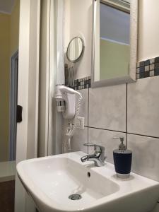 La salle de bains est pourvue d'un lavabo blanc et d'un miroir. dans l'établissement La Città degli Dei, à Agrigente 37 autres photos