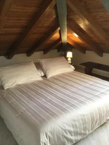ボリアスコにあるLa Mansarda Sul Mareの白いシーツと枕が備わる大きな白いベッド