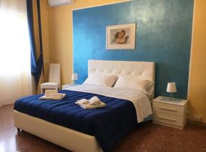 1 dormitorio con 1 cama grande y pared azul en La Città degli Dei, en Agrigento