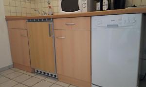 W kuchni znajduje się biała zmywarka i kuchenka mikrofalowa. w obiekcie Apartment Bexor D19 w Hanowerze