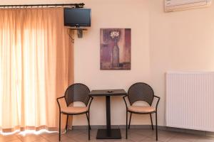 stół z dwoma krzesłami i telewizor w pokoju w obiekcie Diana w mieście Makrakómi
