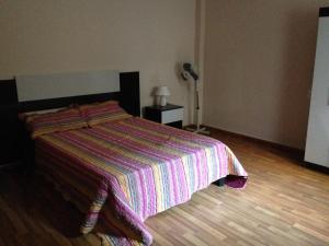 1 dormitorio con 1 cama con manta a rayas en Apartamento en el centro de mercedes URUGUAY, en Mercedes