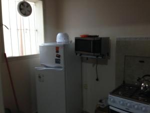 a kitchen with a refrigerator and a clock on the wall at Apartamento en el centro de mercedes URUGUAY in Mercedes +4 photos