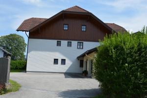 a large white building with a brown roof at Appart Weisse Urlauben am Wolfgangsee in Sankt Gilgen
