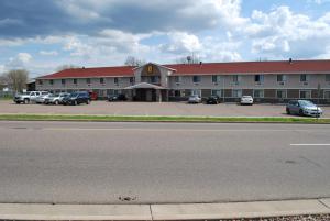 a large building with cars parked in a parking lot at Super 8 by Wyndham Eau Claire WI in Eau Claire