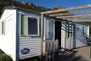 a blue and white tiny house with a porch at La Canardiere in Casta