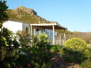 une maison blanche avec une terrasse couverte et une montagne dans l'établissement La Canardiere, à Casta