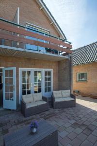 un patio avec deux canapés et un bâtiment dans l'établissement Hotel Eperland, à Epen