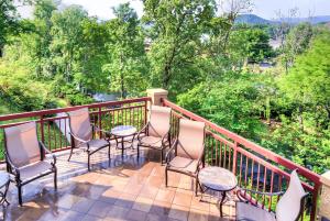 a balcony with chairs and tables and trees at RiverStone Condo Resort & Spa in Pigeon Forge