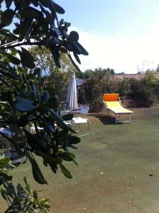 バッサーノ・デル・グラッパにあるLibertyroofgardenの庭に椅子2脚、テーブル1台、傘1本
